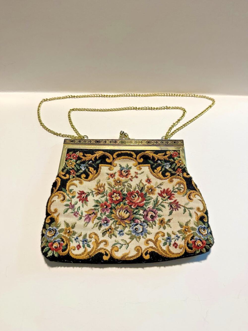 vintage floral tapestry evening bag with a gold metal frame and chain handle.
